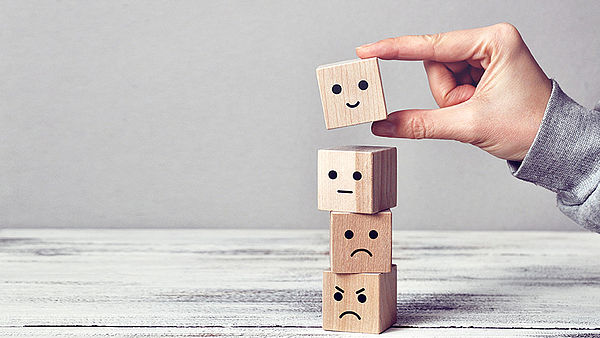 Verschiedene Holzwürfel mit unterschiedlichen Emotionen gestapelt Traurigkeit Wut Ruhe Freude
