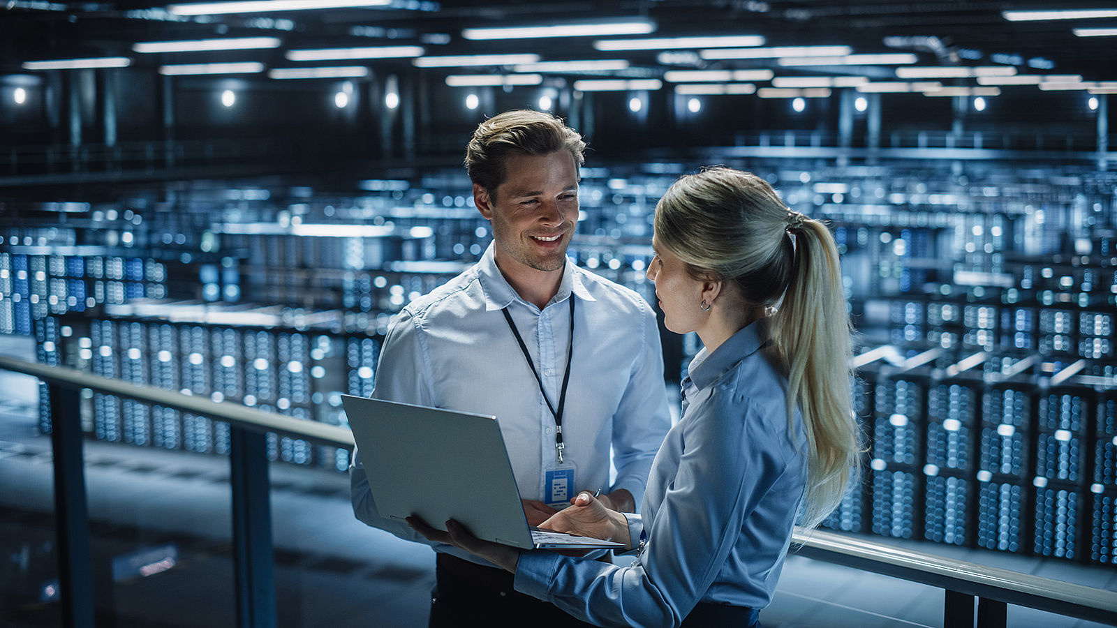 A woman and a man are talking in a server room.