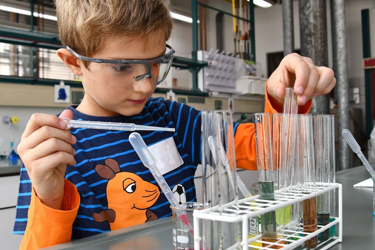 Kleiner Junge steht im Chemielabor der Hochschule Esslingen