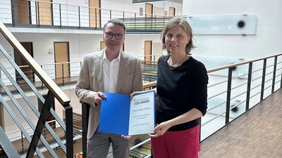 Ein Mann und eine Frau halten eine Urkunde in der Hand