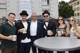 Gruppe von Absolvierenden auf dem Campus zusammen mit dem Rektor