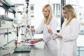 Zwei Frauen mit Kittel und Schutzbrille im Labor