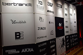 Schwarz-Weiße Wand auf der verschiedene Firmen-Namen stehen