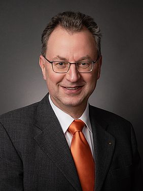 Porträt eines Mannes mit Brille und Anzug
