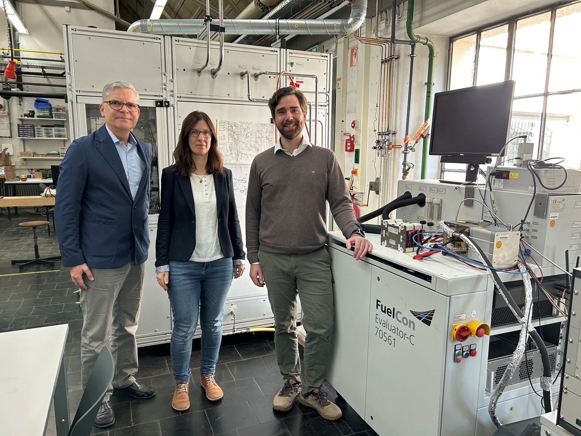 zwei M&auml;nner und eine Frau stehen in einem Labor