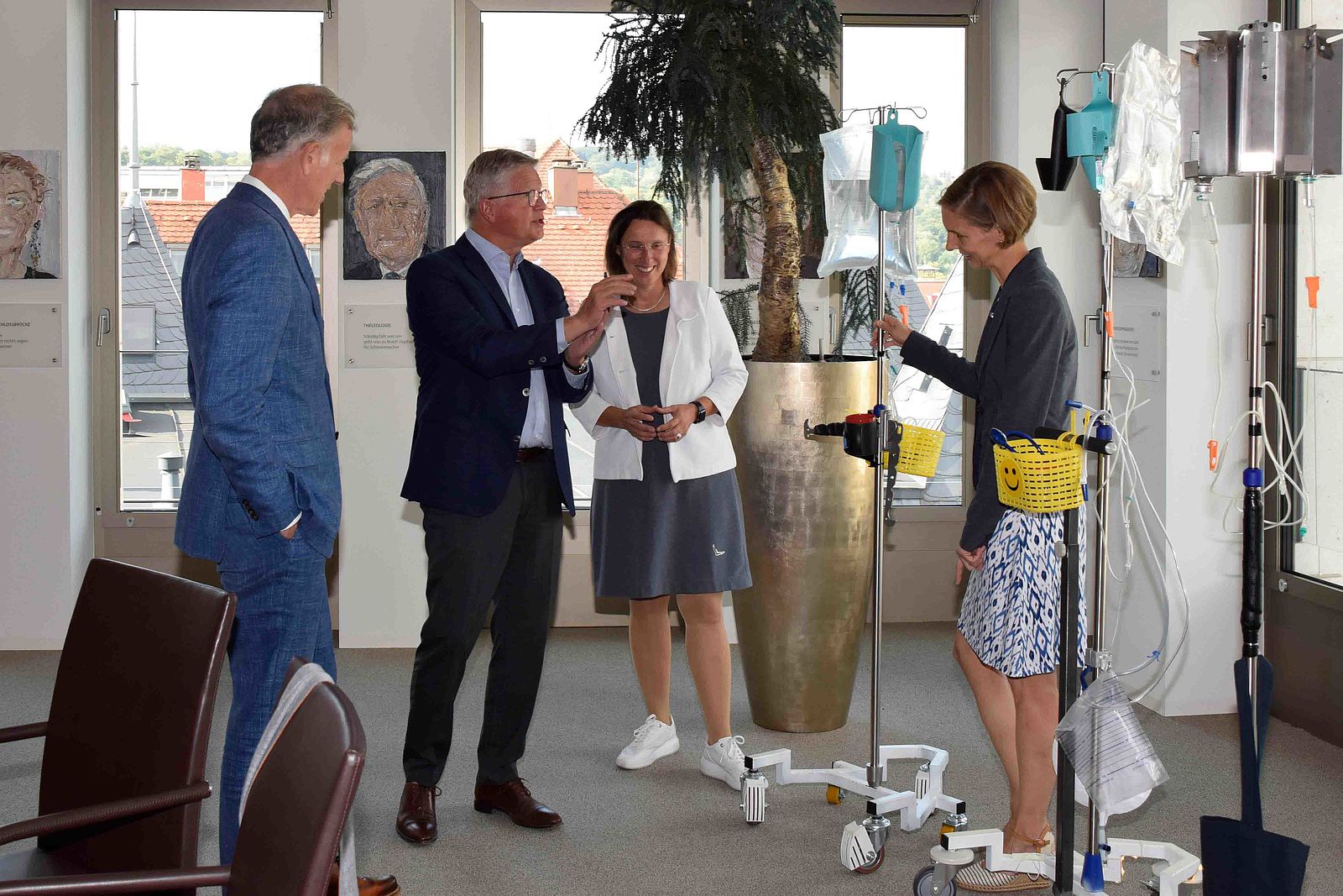 Heinz Eininger, Burkhard Wittmacher, Franziska Meinecke und Astrid Elsbernd reden über die Infusionsständer, die sich im Hintergrund befinden.