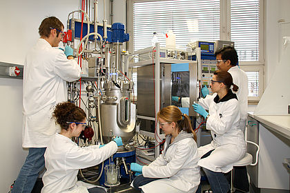 Mehrere Studenten arbeiten am Bioreaktor