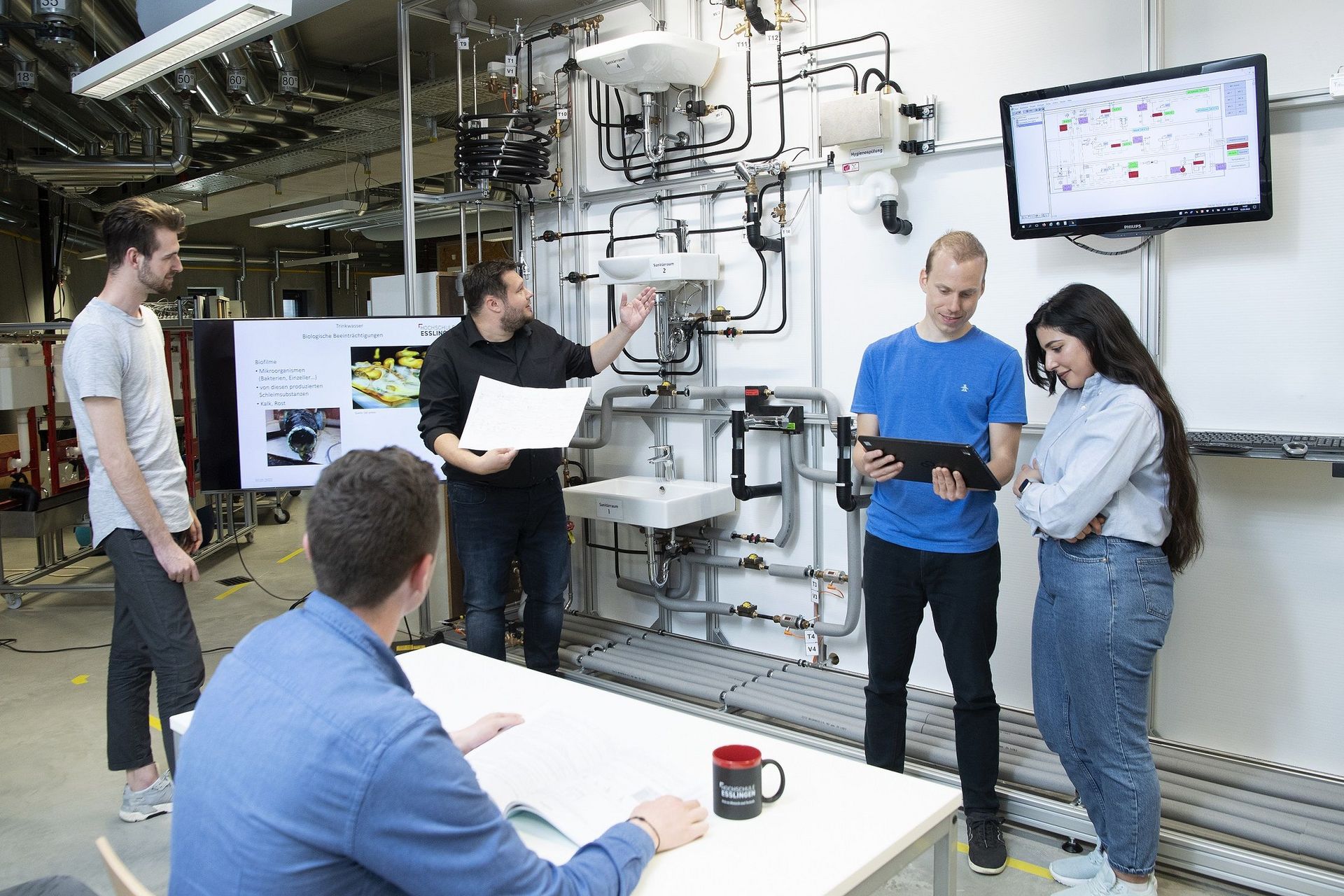 Studierende stehen in einem Labor des Studiengangs Nachhaltige Gebäude- und Energietechnik