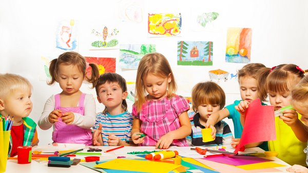 Viele Kleine Kinder spielen am Kindertisch 