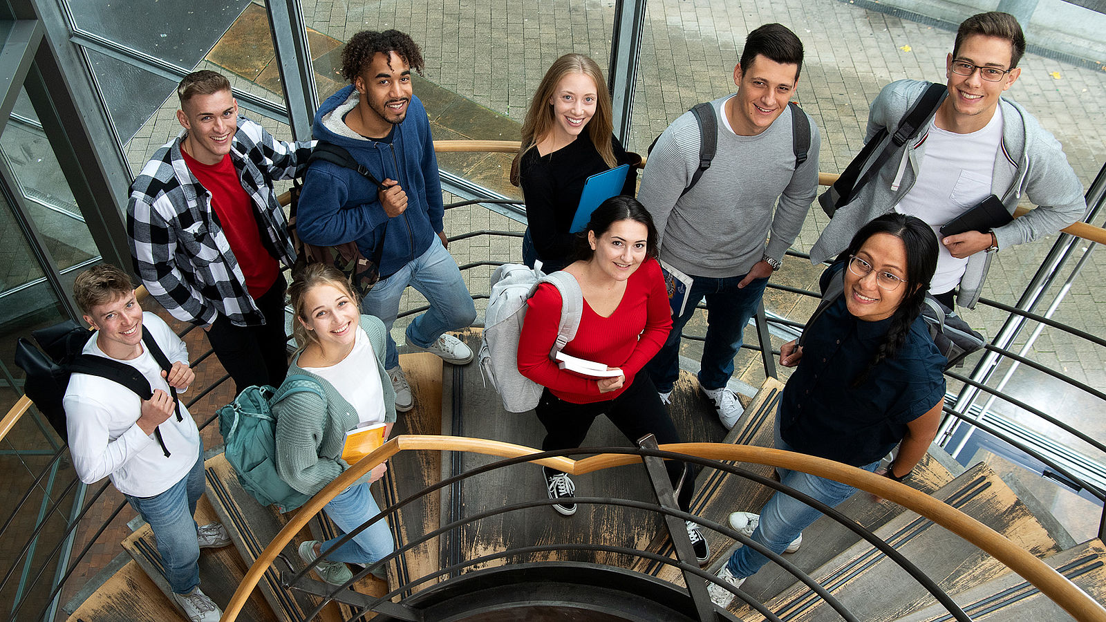 Studierende der Hochschule Esslingen stehen auf einer Treppe und schauen nach oben.