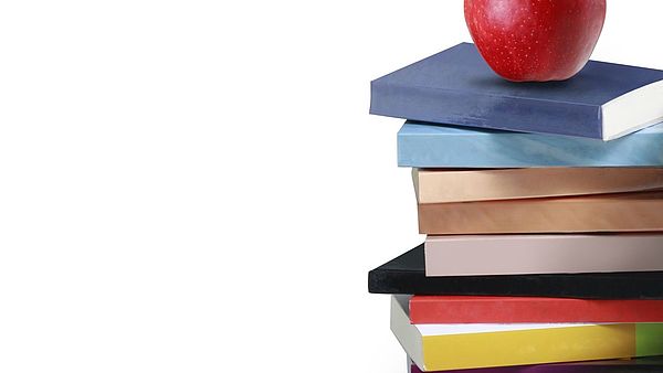 rechts: Bücherstapel mit Apfel darauf. Links: in schwarzer Schrift "Gesundheitsförderung für Studierende"