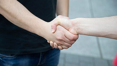Zwei Personen schütteln sich die Hände- Sicht auf den Handschlag