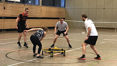 4 Studenten in Sporthalle, die Spikeball spielen