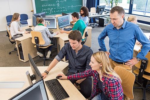 Studierende im Computerraum unter Anleitung eines Professors