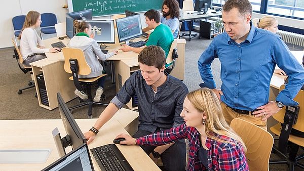 Studierende im Computerraum unter Anleitung eines Professors