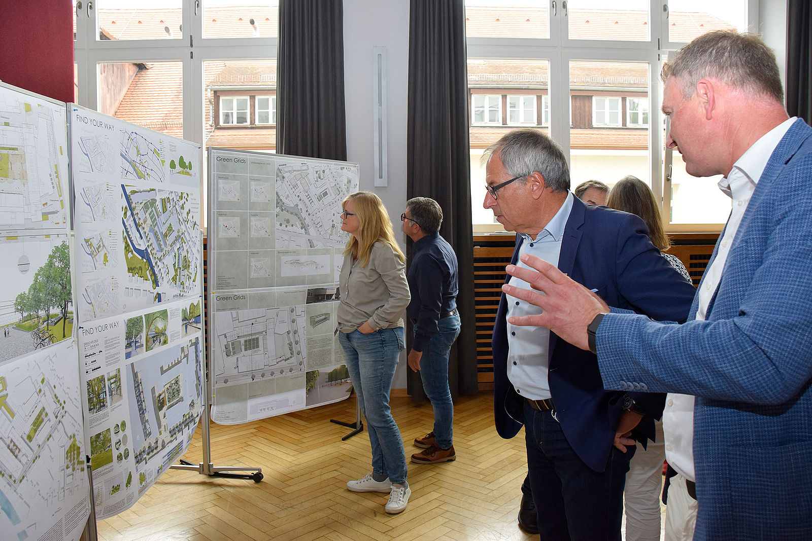 Die Entwürfe zur neuen Gestaltung des Campus Stadtmitte stehen am linken Saalende. Davor unterhalten sich Rektor Prof. Christof Wolfmaier und Baubürgermeister Hans-Georg Sigel.