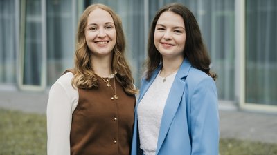 Zwei Graduierte blicken in die Kamera