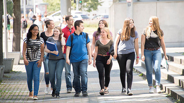 Studierendengruppe läuft auf dem Campus