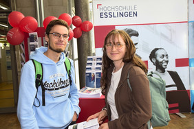Mann und Frau vor einem Infostand