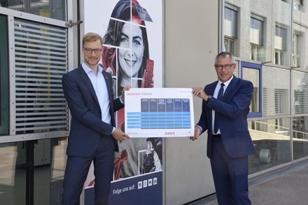 Zwei Männer halten ein Plakat in der Hand