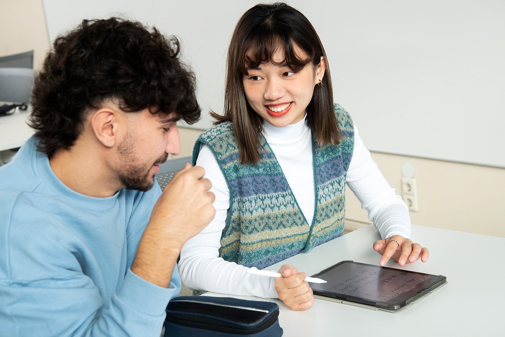 Ein Student und eine Studentin der Wirtschaftsinformatik Hochschule Esslingen schauen ins Tablet.