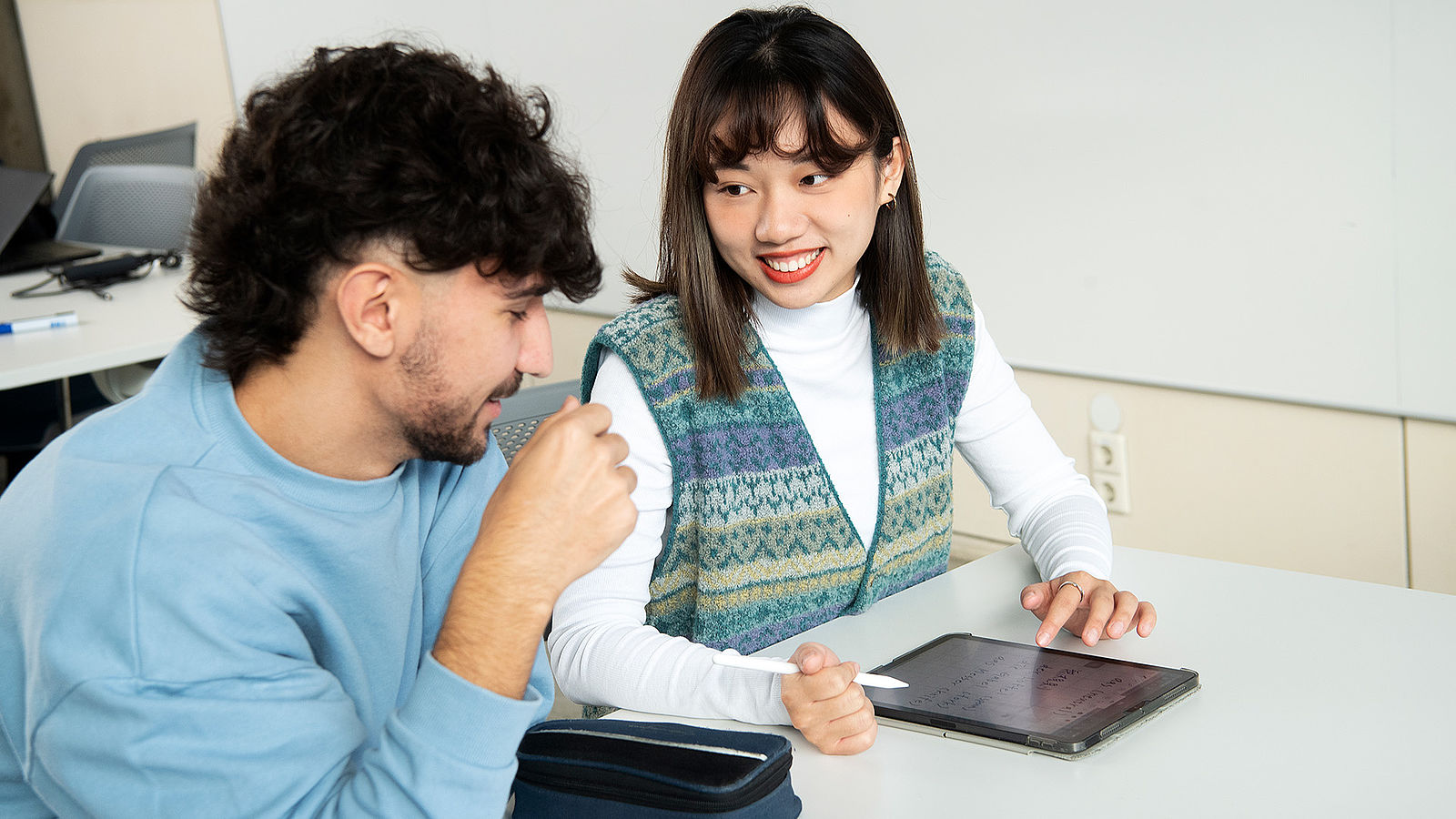 Ein Student und eine Studentin der Wirtschaftsinformatik Hochschule Esslingen schauen ins Tablet.