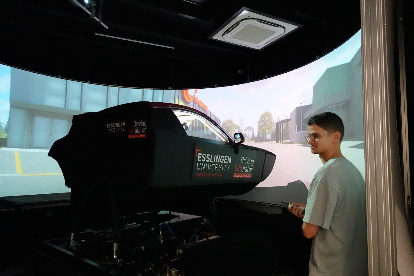 Fahrsimulator vor einer künstlichen Landschaft