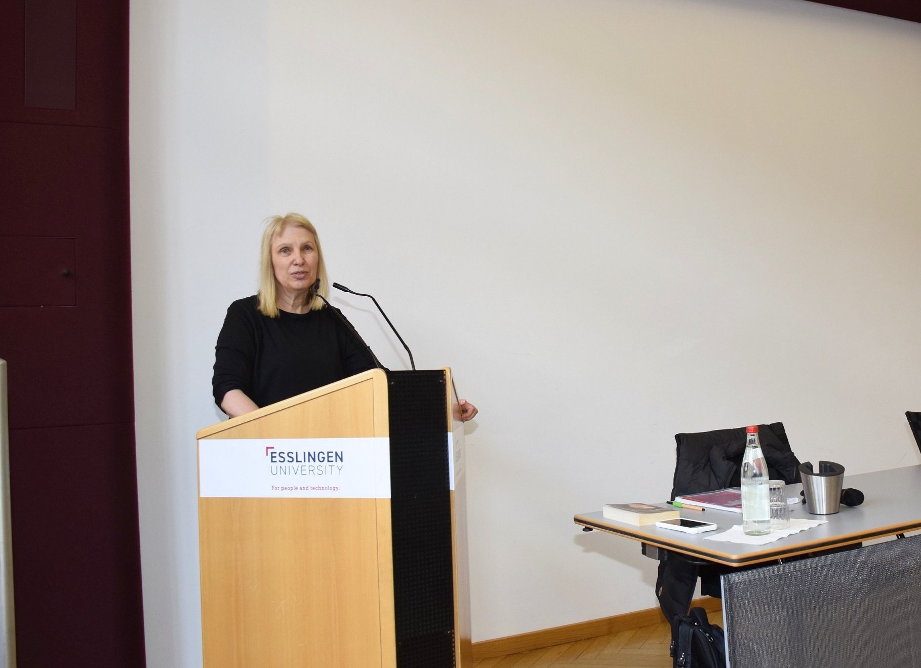 Frau steht am Rednerpult und spricht