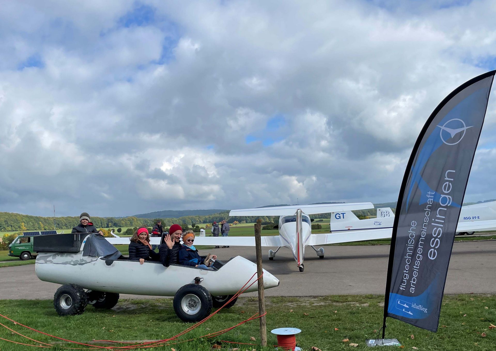 Prof. Dr. Diefenbach sitzt mit seinen drei Kindern in einem Rückholfahrzeug beim Segelflugtag in Grabenstetten.