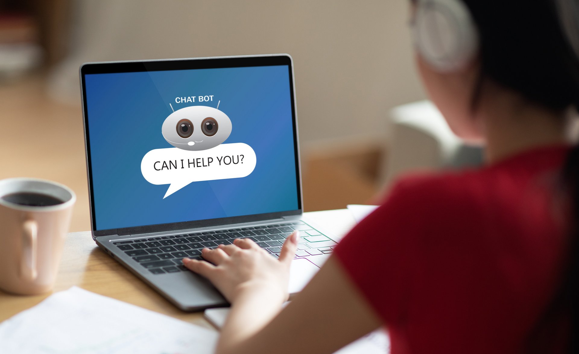 junge Frau am Laptop chattet mit Chatbot