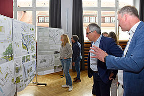Die Entwürfe zur neuen Gestaltung des Campus Stadtmitte stehen am linken Saalende. Davor unterhalten sich Rektor Prof. Christof Wolfmaier und Baubürgermeister Hans-Georg Sigel.