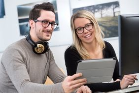 Mann und Frau mit einem Tablet in der Hand