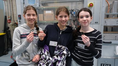 3 M&auml;dchen halten Schl&uuml;sselanh&auml;nger in die Kamera