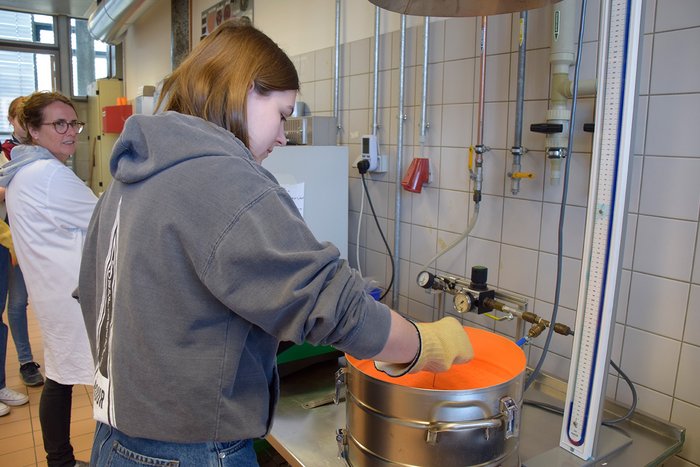 Im Labor f&uuml;r Lacke wird der Anh&auml;nger in den Pulverlack getaucht.