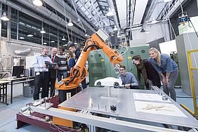 Männer und Frauen in einem Labor mit einem großen Roboter