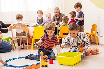 Kinder sitzen auf dem Boden und basteln