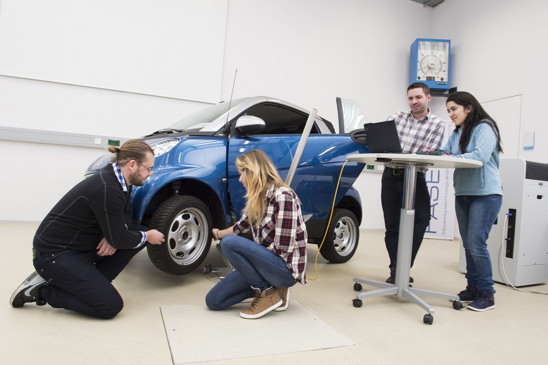 Studierende an einem Auto