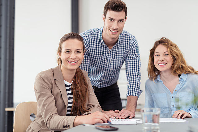 Three young people at their desks