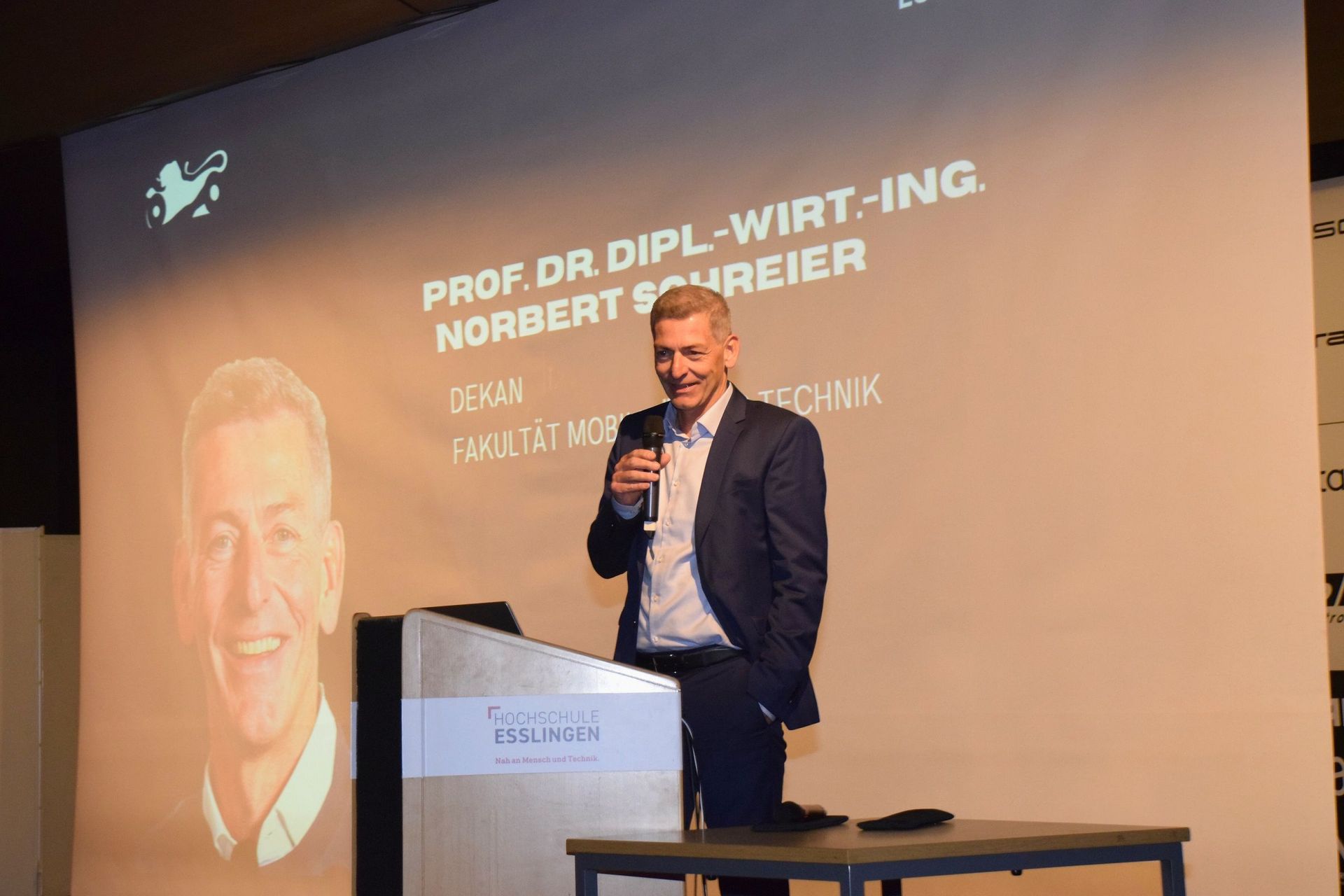 Mann steht am Rednerpult