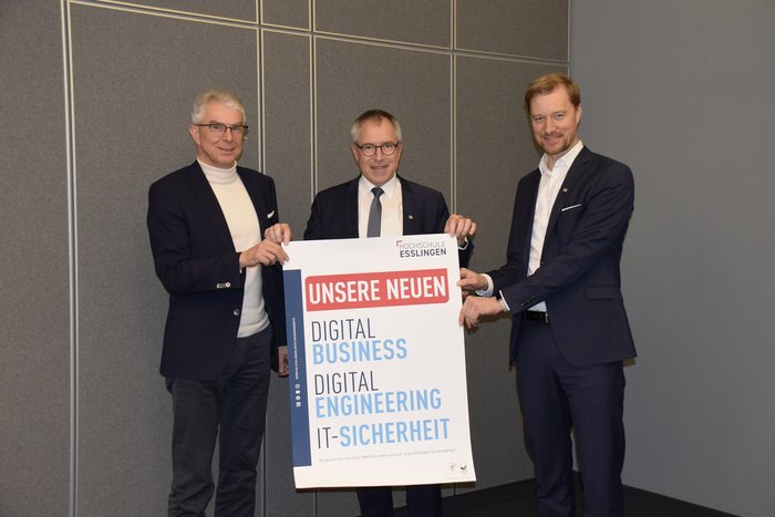 Drei Männer halten ein Plakat in der Hand