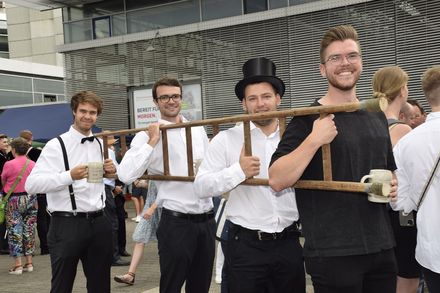 Mit der Leiter in der Hand laufen Absolvierende der Hochschule Esslingen durch die Stadt