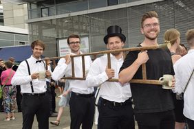 Mit der Leiter in der Hand laufen Absolvierende der Hochschule Esslingen durch die Stadt
