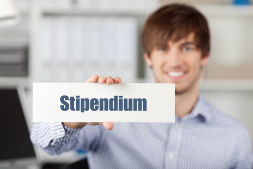 Student zeigt Schild mit dem Wort "Stipendium" 