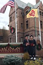 Zwei Studenten stehen mit ihren Abschlüssen vor der Gannon University 