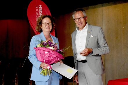 Frau mit Blumenstrauß und Mann schauen in die Kamera