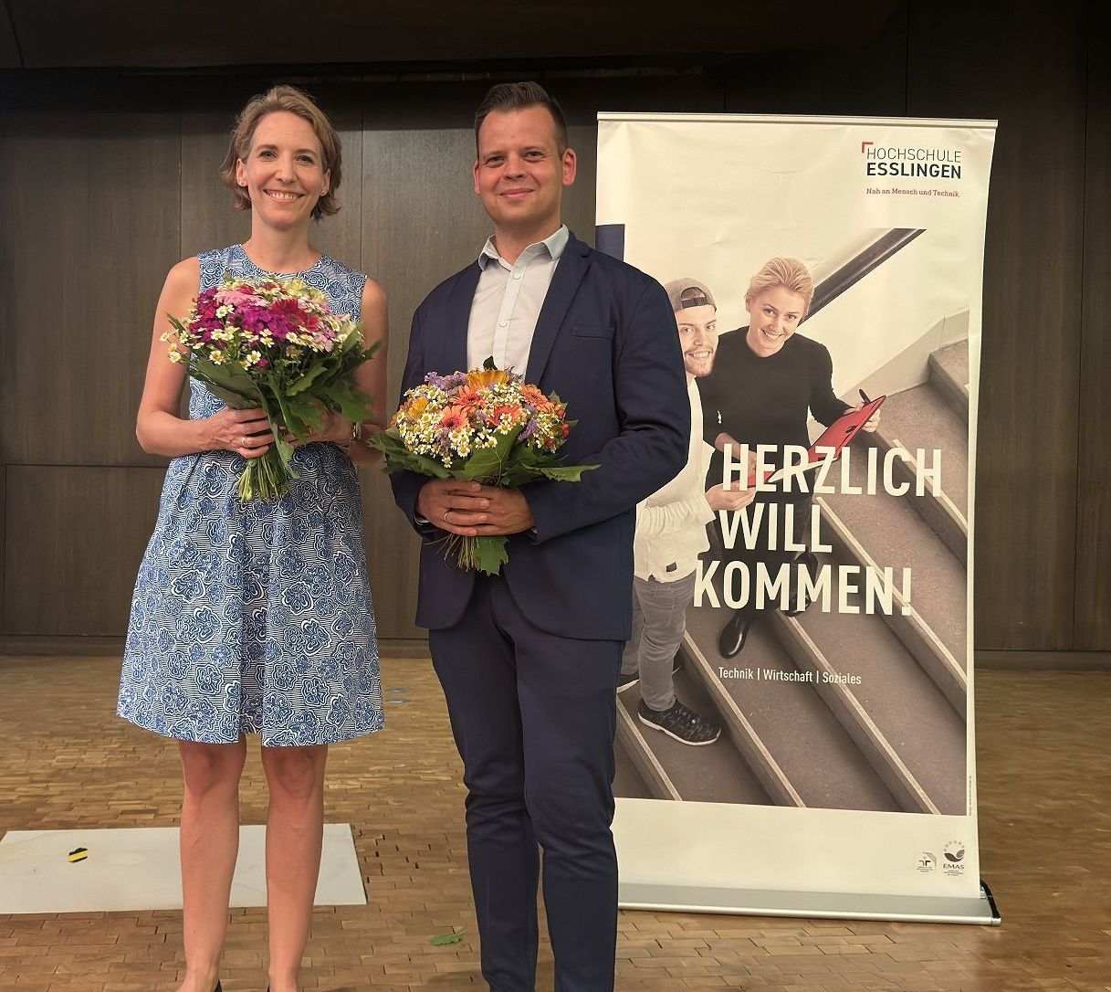Mann und Frau mit Blumenstrauß stehen auf einer Bühne