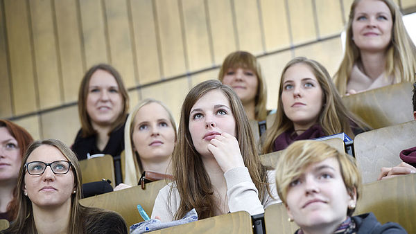 mehrere Studierende im Hörsaal von vorne beim Zuhören einer Vorlesung