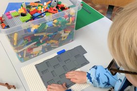 Ein kleiner Junge bastelt mit Lego