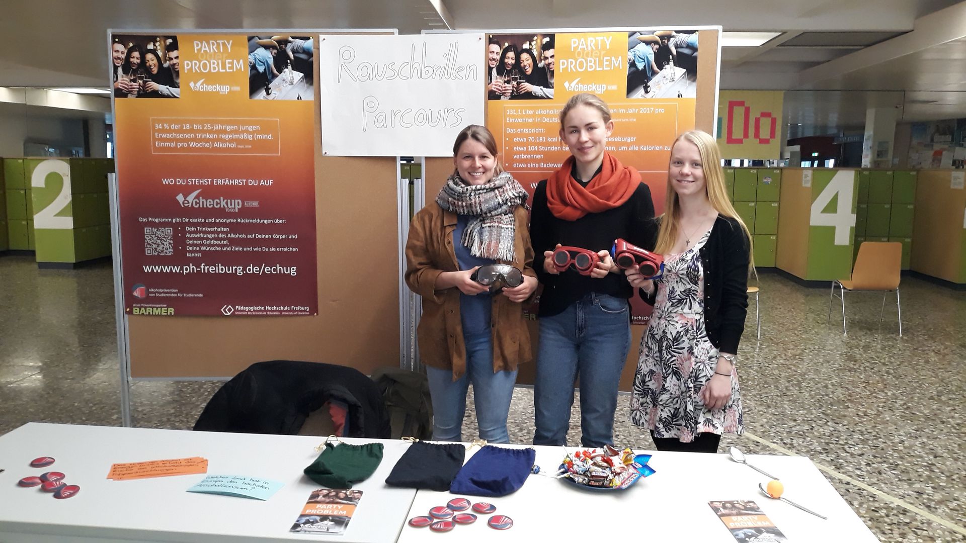 Drei junge Frauen an einem Beratungsstand