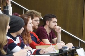 Studierende sitzen im Hörsaal und hören interessiert einer Vorlesung zu 